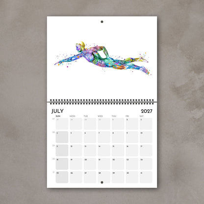 2027 anatomy wall calendar July page showing watercolor human body muscles in swimming, sports medical art